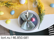 Праздничное сервирование стола, украшенное мимозой и пасхальными яйцами. Стоковое фото, фотограф Pixel_shot / Фотобанк Лори