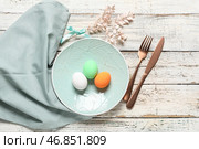 Прекрасное праздничное сервировочное полотенце для Пасхи с яйцами и веткой на светлом деревянном фоне. Стоковое фото, фотограф Pixel_shot / Фотобанк Лори
