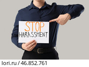 Бизнесмен указывает на бумагу с текстом "ПРЕКРАТИТЕ ПРЕСЛЕДОВАНИЯ" на светлом фоне, крупный план. Стоковое фото, фотограф Pixel_shot / Фотобанк Лори