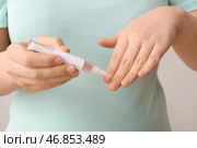 Женщина наносит масло для кутикулы с помощью ручки на белом фоне, крупным планом. Стоковое фото, фотограф Pixel_shot / Фотобанк Лори
