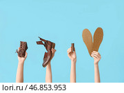 Женские руки с кусочками обуви, стельками и швейной нитью на голубом фоне. Концепция починки обуви. Стоковое фото, фотограф Pixel_shot / Фотобанк Лори