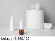 Бутылки капель с таблетками и коробка с салфетками на столе возле серой стены. Концепция аллергии. Стоковое фото, фотограф Pixel_shot / Фотобанк Лори