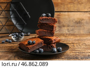 Тарелка с кусочками вкусного шоколадного брауни на деревянном фоне. Стоковое фото, фотограф Pixel_shot / Фотобанк Лори