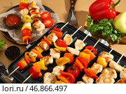 Современный электрический гриль с вкусными куриными шашлычками и овощами на бежевом деревянном фоне, крупным планом. Стоковое фото, фотограф Pixel_shot / Фотобанк Лори