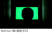 Man watching TV with chromakey that hanging on the wll at night at home. Стоковое фото, фотограф David Kashakhi / Фотобанк Лори