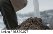 Man with the flag on top of the mountain inserts a flag in the ground, bottom view close up. Стоковое фото, фотограф David Kashakhi / Фотобанк Лори
