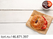 Вкусный бублик с кунжутом и клубничным вареньем на светлом деревянном фоне. Стоковое фото, фотограф Pixel_shot / Фотобанк Лори
