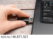 Женщина использует черный USB-накопитель с современным ноутбуком на белом деревянном фоне. Стоковое фото, фотограф Pixel_shot / Фотобанк Лори