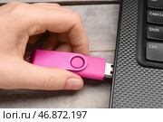 Женщина использует розовую флешку с современным ноутбуком на белом деревянном фоне. Стоковое фото, фотограф Pixel_shot / Фотобанк Лори
