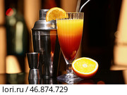 Стакан вкусной текилы Санрайз, коктейльный шейкер и двойной джиггер на темном столе в баре. Стоковое фото, фотограф Pixel_shot / Фотобанк Лори