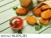 Чаша вкусного кетчупа и наггетсов на зеленом деревянном фоне. Стоковое фото, фотограф Pixel_shot / Фотобанк Лори