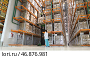 Warehouse worker taking package in the shelf in a large warehouse in a large warehouse. Стоковое фото, фотограф David Kashakhi / Фотобанк Лори