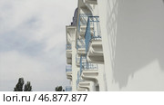 Side view of balconies with blue wrought iron railing of modern building, architectural background. Стоковое фото, фотограф David Kashakhi / Фотобанк Лори
