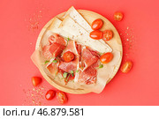 Тарелка с ломтиками вкусного хамона и сыра на красном фоне. Стоковое фото, фотограф Pixel_shot / Фотобанк Лори