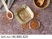 Чаша с льняным маслом и семенами на сером фоне. Стоковое фото, фотограф Pixel_shot / Фотобанк Лори