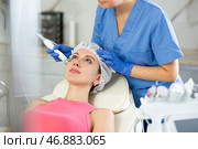 Young girl getting facial rf-lifting procedure of smoothes wrinkles and tightens skin on face in beauty salon. Concept of professional cosmetology. Стоковое фото, фотограф Яков Филимонов / Фотобанк Лори