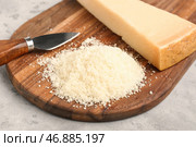 Деревянная доска с вкусным тертым сыром пармезан на фоне гранж, крупным планом. Стоковое фото, фотограф Pixel_shot / Фотобанк Лори