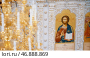 Chandelier with artificial candles in the temple with iconostasis. Стоковое фото, фотограф David Kashakhi / Фотобанк Лори