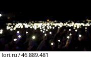Audience holding phones with shining flashlights during the concert, romantic atmosphere. Стоковое фото, фотограф David Kashakhi / Фотобанк Лори