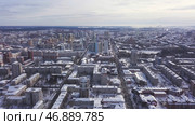 Aerial view of the city and many houses, roads, and yards in the winter time. Стоковое фото, фотограф David Kashakhi / Фотобанк Лори