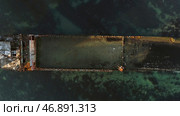 Aerial top view for wrecked ship along the rocky coast in blue water. Стоковое фото, фотограф David Kashakhi / Фотобанк Лори