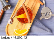 Доска с бокалом вкусного коктейля "Олд Фэшн" и кусочками апельсина на голубом деревянном фоне. Стоковое фото, фотограф Pixel_shot / Фотобанк Лори