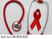 Красная лента со стетоскопом на светлом фоне. Концепция Дня борьбы со СПИДом. Стоковое фото, фотограф Pixel_shot / Фотобанк Лори