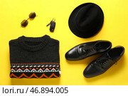 Мужской свитер, фетровая шляпа, туфли, солнцезащитные очки и ключи от машины на желтом фоне. Стоковое фото, фотограф Pixel_shot / Фотобанк Лори