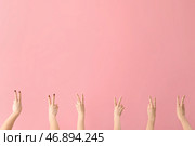 Женские руки, показывающие жест мира на розовом фоне. Стоковое фото, фотограф Pixel_shot / Фотобанк Лори