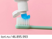 Выдавливание зубной пасты на щетку на розовом фоне, крупным планом. Стоковое фото, фотограф Pixel_shot / Фотобанк Лори