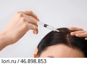 Молодая женщина с проблемой выпадения волос делает себе укол на светлом фоне. Стоковое фото, фотограф Pixel_shot / Фотобанк Лори