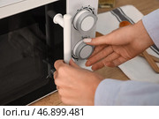 Женщина использует микроволновую печь на кухне, крупным планом. Стоковое фото, фотограф Pixel_shot / Фотобанк Лори