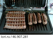 Приготовление чевапчичи (колбасок) на электрическом гриле - Cooking chevapchichi (sausage) on an electric grill. Стоковое фото, фотограф Владислав Дельдюгинов / Фотобанк Лори