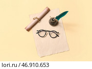 Старый лист бумаги с перьевой ручкой, чернильницей, свитком и очками на бежевом фоне. Стоковое фото, фотограф Pixel_shot / Фотобанк Лори