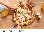 Руки берут кусочки вкусной пиццы Маргарита на деревянном фоне. Стоковое фото, фотограф Pixel_shot / Фотобанк Лори