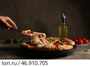 Рука берет кусок вкусной пиццы Маргарита на фоне в стиле гранж. Стоковое фото, фотограф Pixel_shot / Фотобанк Лори