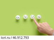 Мужчина указывает на смайлы с оценками на зеленом фоне. Концепция опроса. Стоковое фото, фотограф Pixel_shot / Фотобанк Лори