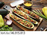 Доска с фаршированными мясом лодочками из кабачков на деревянном фоне. Стоковое фото, фотограф Pixel_shot / Фотобанк Лори