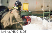 Firefighters with large hose extinguish fire. Стоковое фото, фотограф David Kashakhi / Фотобанк Лори