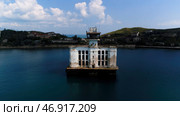 Shot.A large white building controlling the raging sea next to bridges and mountains. Стоковое фото, фотограф David Kashakhi / Фотобанк Лори