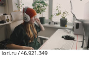Focused player wears noise-canceling headset to enter gaming mode. Neatly arranged accessories, sleek monitor, and organized space create optimal environment for deep concentration and performance. Стоковое видео, видеограф Енваев Андрей / Фотобанк Лори