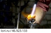 Blacksmith aligns leaves of iron rose and makes the final shape of the flower. Стоковое фото, фотограф David Kashakhi / Фотобанк Лори