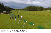 Golfers hitting golf shot with club on course while on summer vacation, aerial. Стоковое фото, фотограф David Kashakhi / Фотобанк Лори