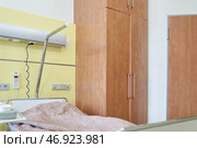 There is an inpatient bed in the postoperative ward against the background of the closet. Modern adjustable bed for hospital patients. With space to copy. Стоковое фото, фотограф Darya Komarova / Фотобанк Лори