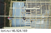 Aerial view of two senior men building a wooden frame house in the summer on their own location. Стоковое фото, фотограф David Kashakhi / Фотобанк Лори