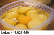 Close up for egg yolks in the plastic container, cooking concept. Стоковое фото, фотограф David Kashakhi / Фотобанк Лори