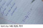 Student solves the equation on paper. Стоковое фото, фотограф David Kashakhi / Фотобанк Лори