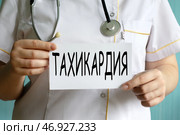 ТАХИКАРДИЯ - слово на белом листе в руках врача. Стоковое фото, фотограф Жанна Гапанович / Фотобанк Лори