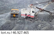 Excavator falls asleep rubble in dumper on outdoor quarry in extraction of minerals. Стоковое фото, фотограф David Kashakhi / Фотобанк Лори