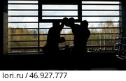 Two male boxers training in the dark gym near the window with daylight. Стоковое фото, фотограф David Kashakhi / Фотобанк Лори